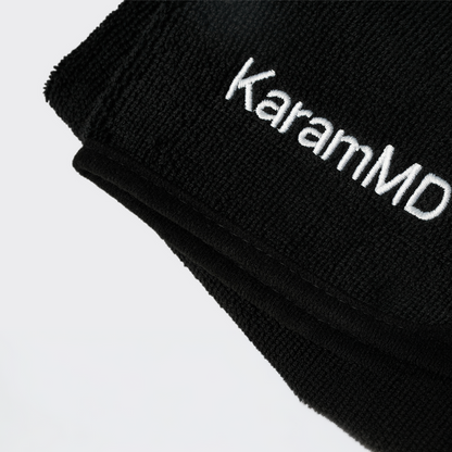 Black face towel with 'KaramMD' embroidered on a light gray background