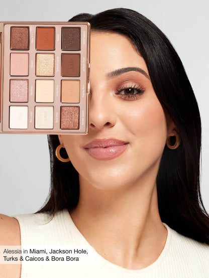 Woman with makeup palette over her face, with a neutral background