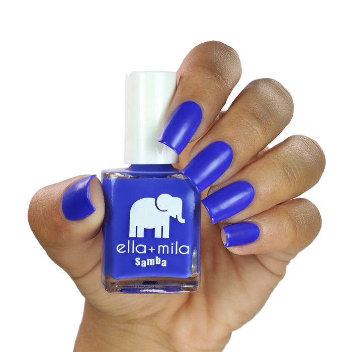 When the Sun Goes Down cobalt blue nail polish on a medium skin tone, hand holding the bottle