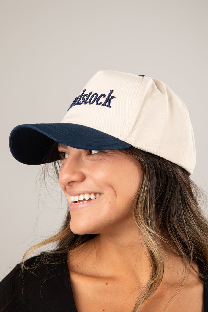 Person wearing a cap with 'Woodstock' text on a plain background