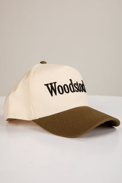 Two-tone cap with 'Woodstock' logo on a light gray background