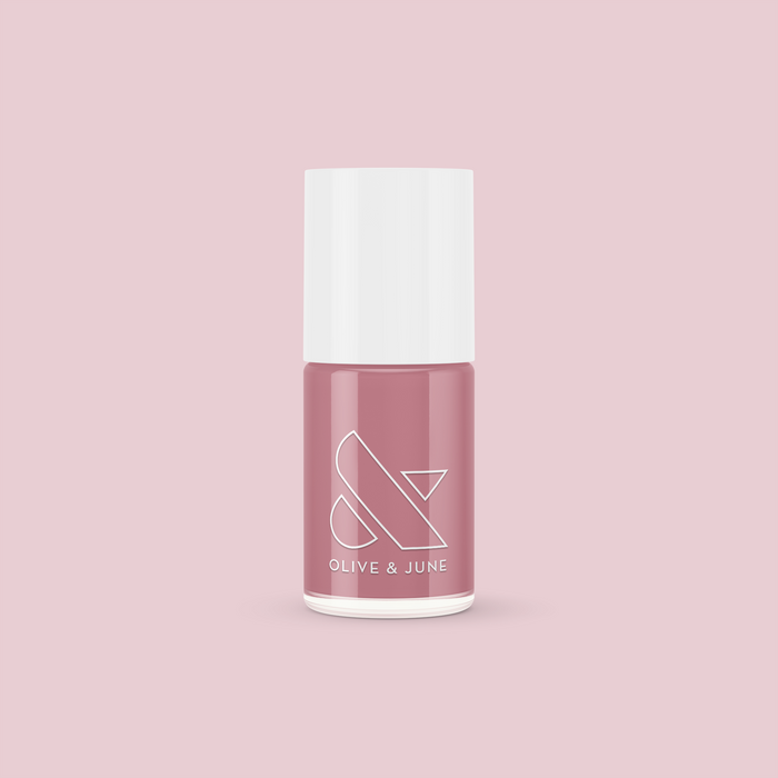 Bottle of Yogurt Parfait nail polish in dusty rose pink shade by Olive and June on light pink background